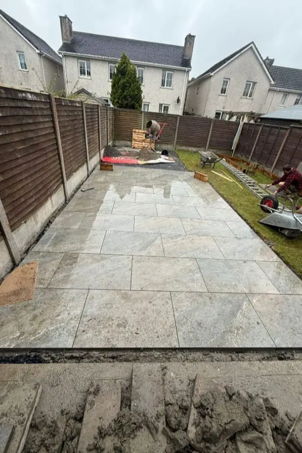 New porcelain patio being installed in a Waterford Garden 